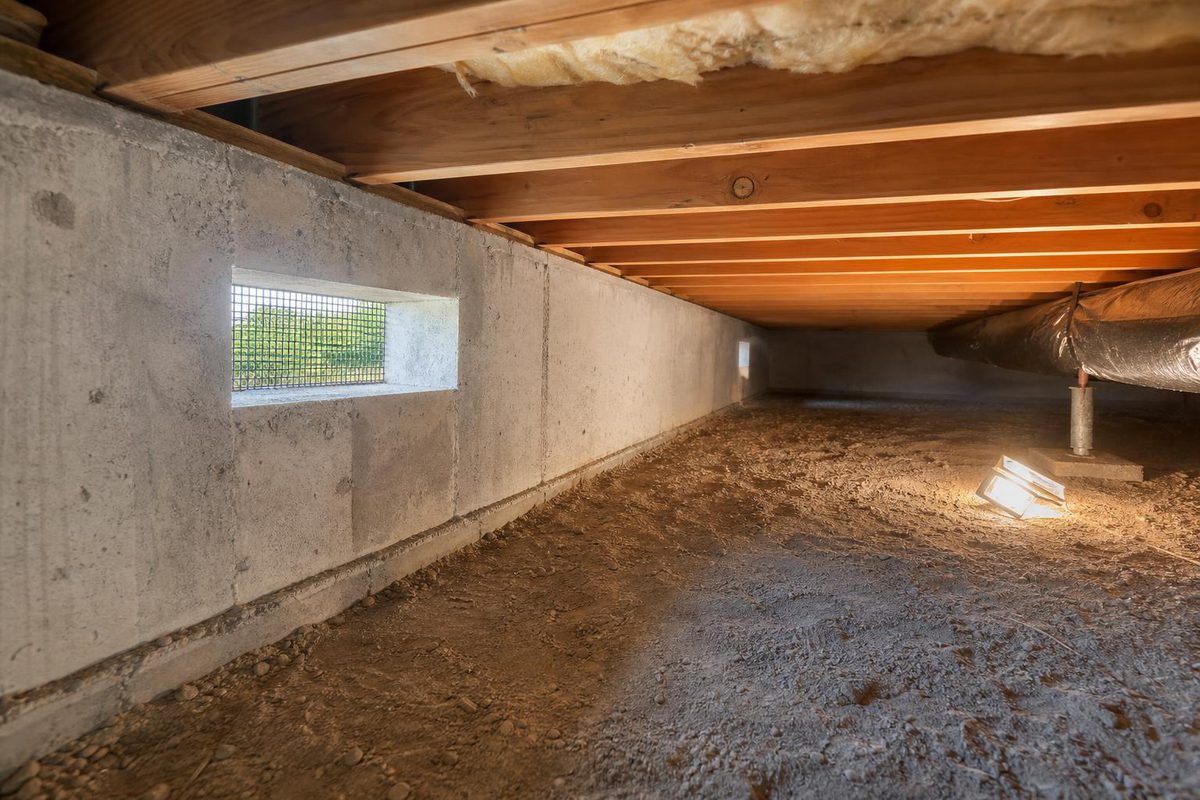 A crawlspace with a soil floor, concrete stem wall and a foundation vent